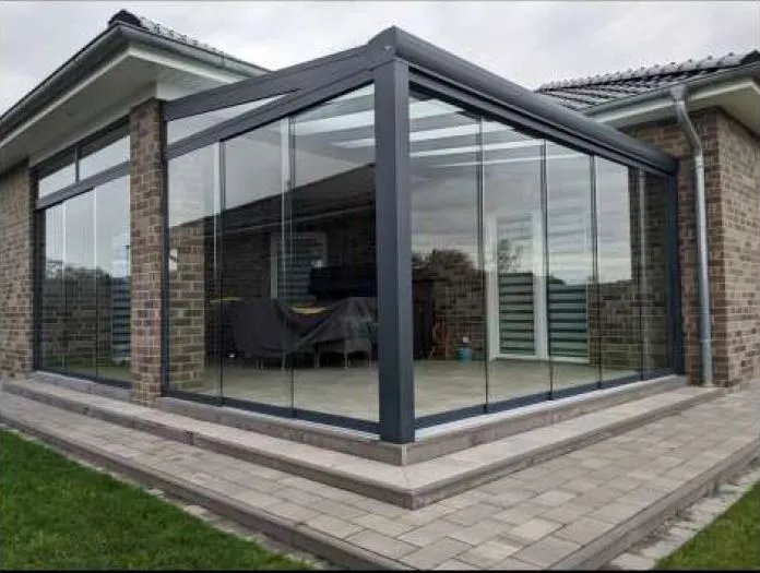 Terrasse an einem Klinkerbungalow, rundum mit Glaselementen geschlossen