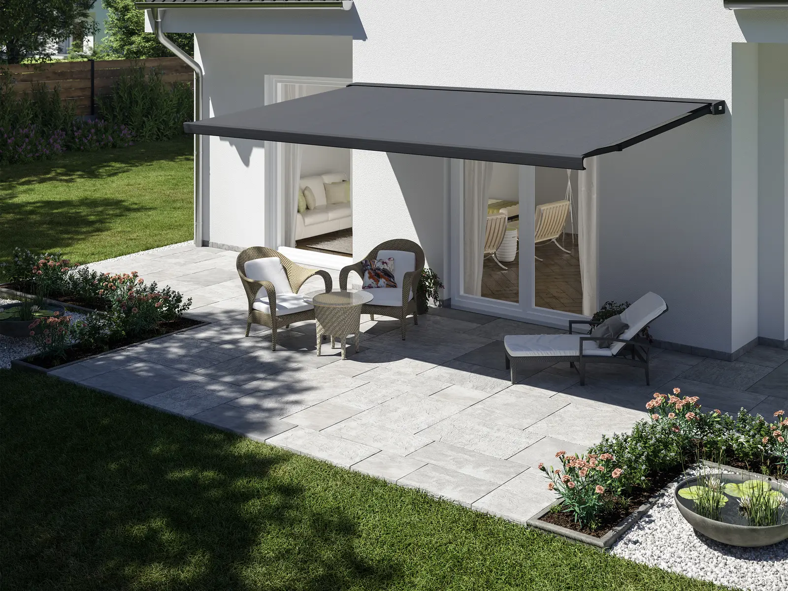 Markise mit anthrazitfarbenem Tuch über der Terrasse eines weißen Giebelhauses